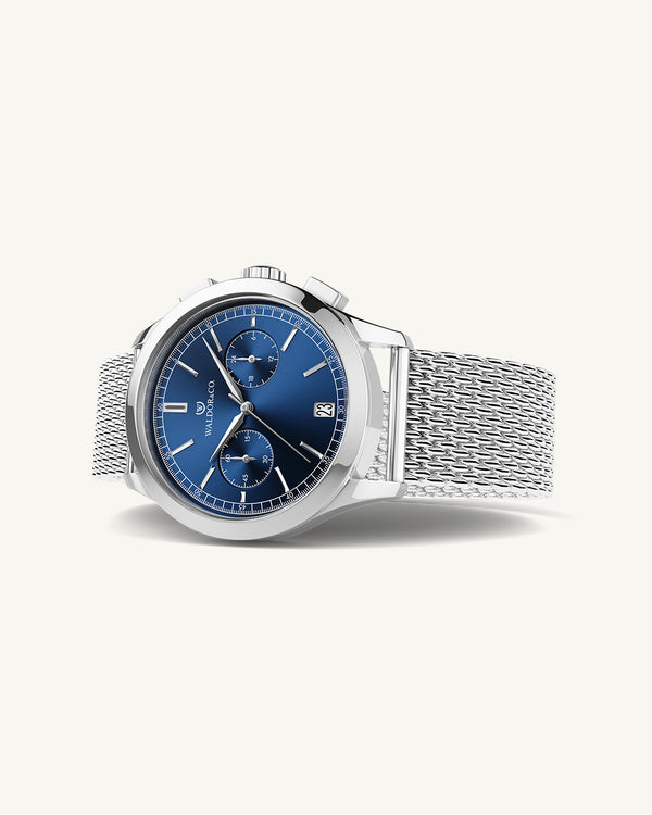 En rund herrklocka i rodiumpläterat silver från WALDOR & CO. med blå sunray urtavla och en sekundvisare. Seiko urverk. Modellen är Chrono 44 Sardinia 44mm.