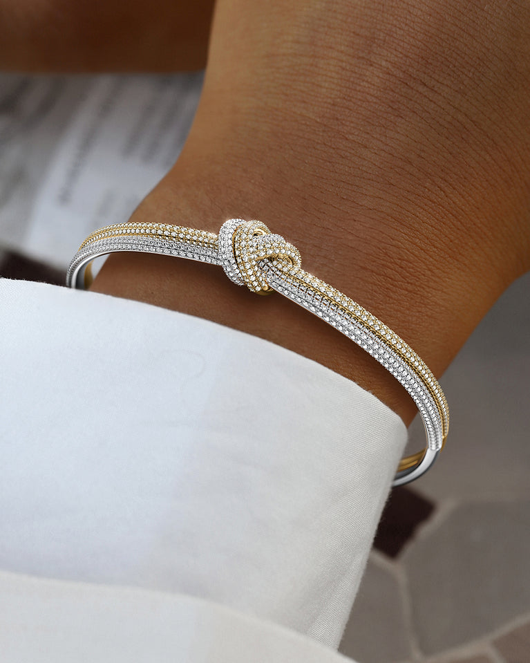 A Bangle in 14k-gold plated and silver polished copper from Waldor & Co. One size. The model is Dual Knot Bangle Pavè.