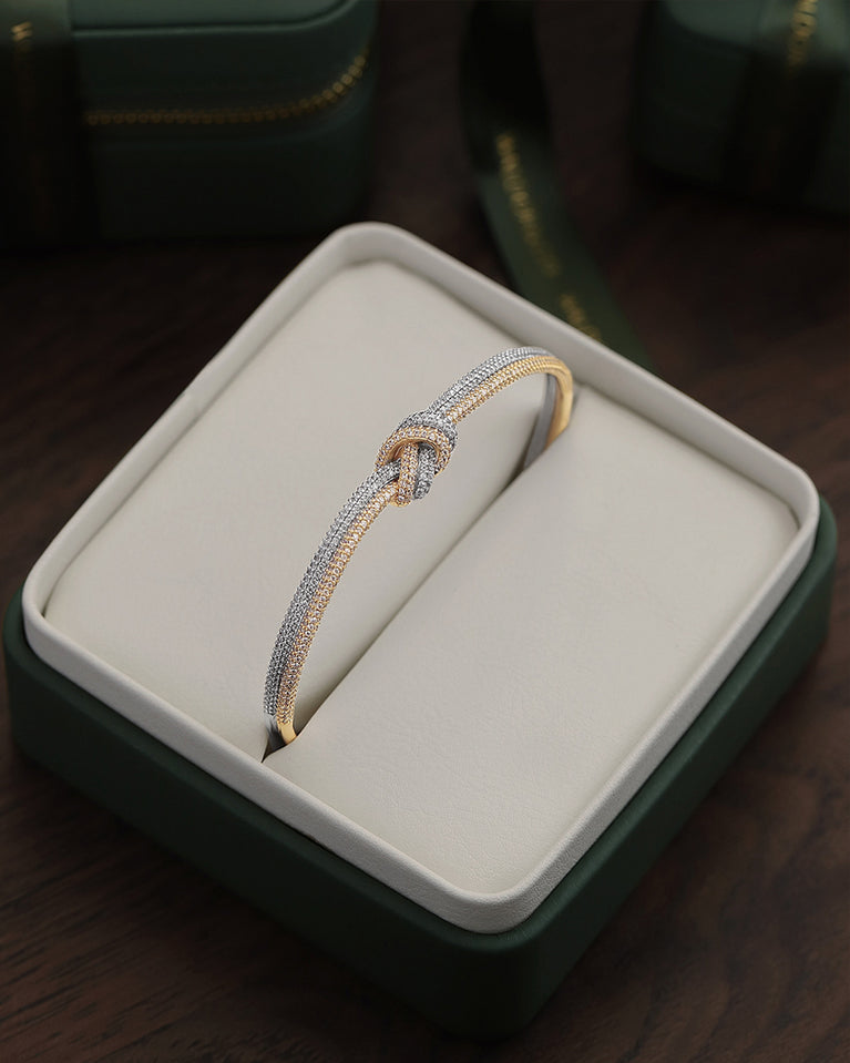 A Bangle in 14k-gold plated and silver polished copper from Waldor & Co. One size. The model is Dual Knot Bangle Pavè.