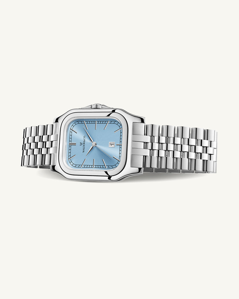 A square womens watch in silver and 14k gold from Waldor & Co. with light blue sunray dial and a second hand. Seiko movement. The model is Delight 32 Chelsea 28x32mm.