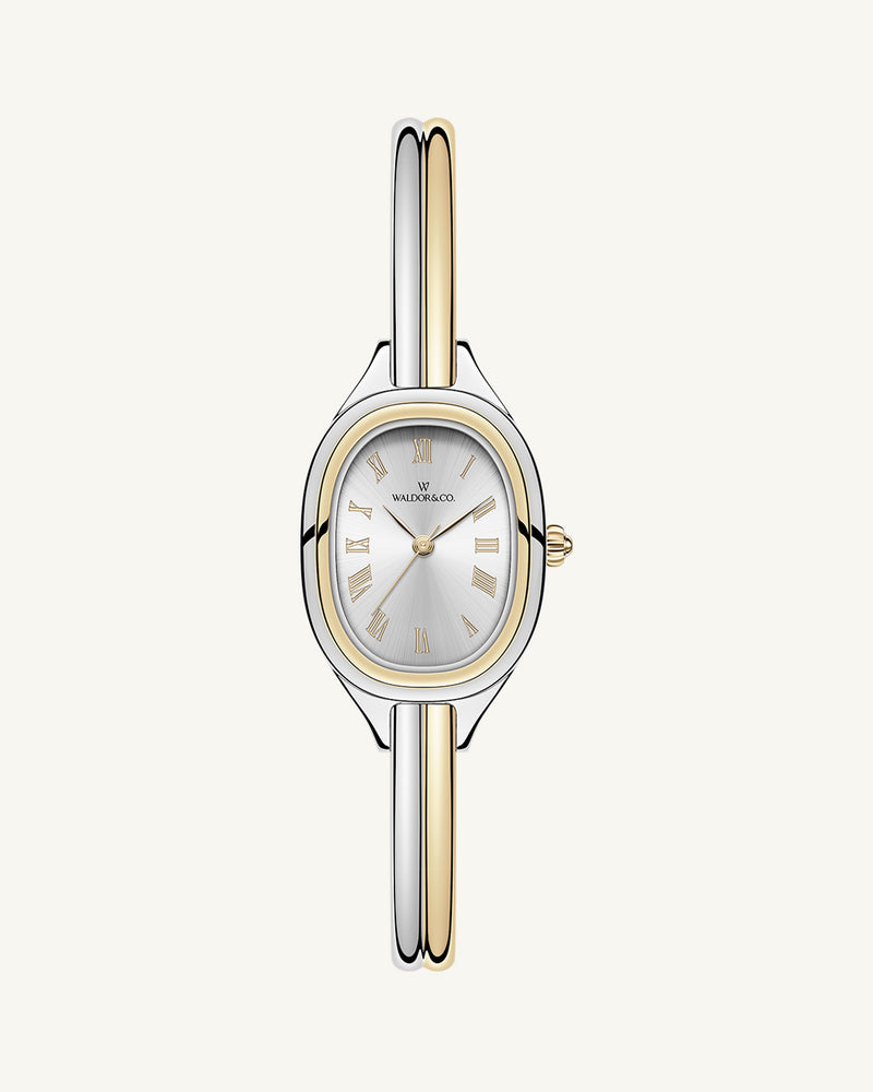 An ellipse shaped womens watch in Rhodium-plated 316L stainless steel from Waldor & Co. with silver sunray dial in brass. Mineral glass with sapphire crystal coating. Seiko movement. The model is Dual Bangle Watch.