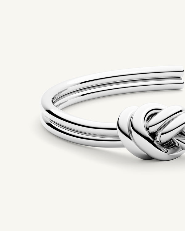 A Bangle Bracelet in polished Silver plated-316L stainless steel from Waldor & Co. The model is Dual Knot Bangle Polished.
