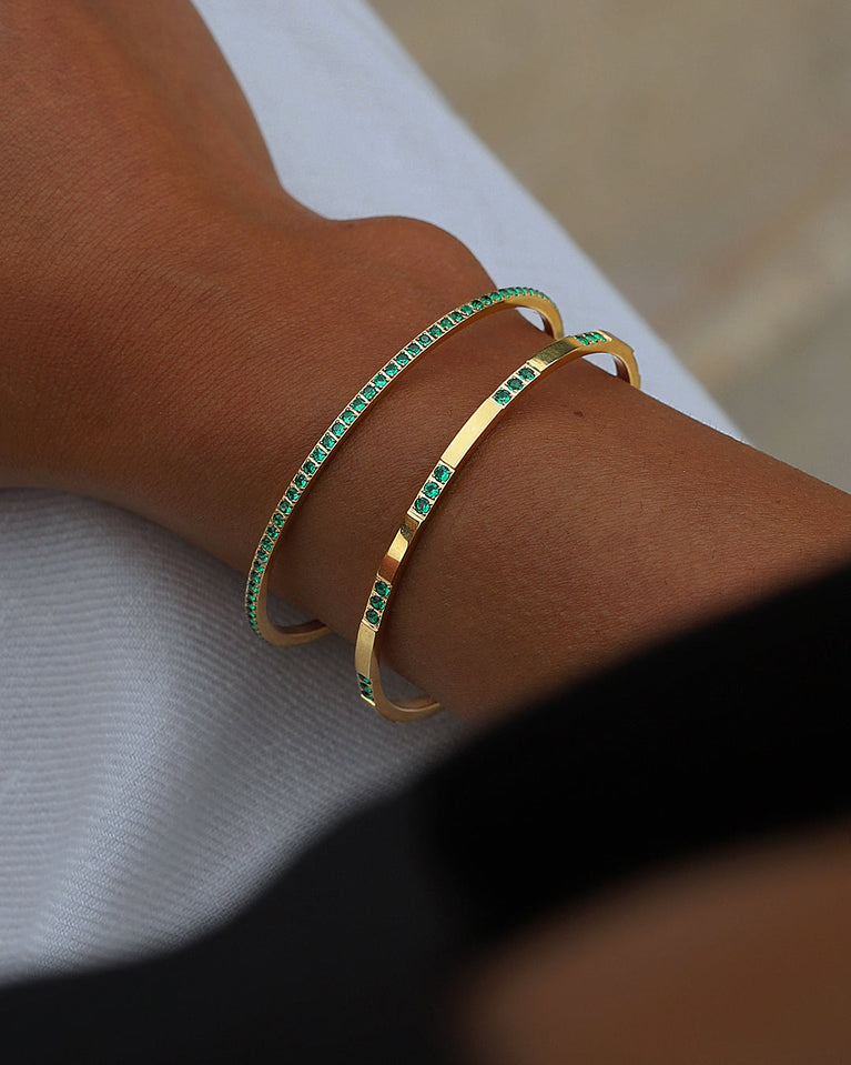  A Bangle in 14k gold-plated 316L stainless steel with green stones from Waldor & Co. One size. The model is Dulcet Bangle Polished.