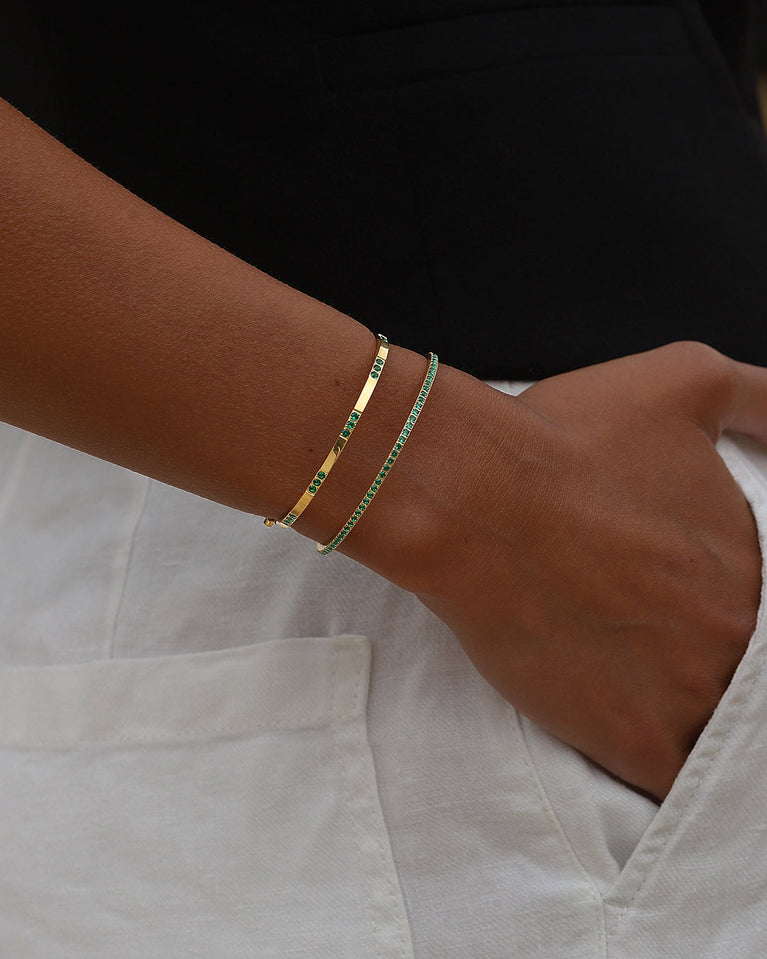  A Bangle in 14k gold-plated 316L stainless steel with green stones from Waldor & Co. One size. The model is Dulcet Bangle Polished.