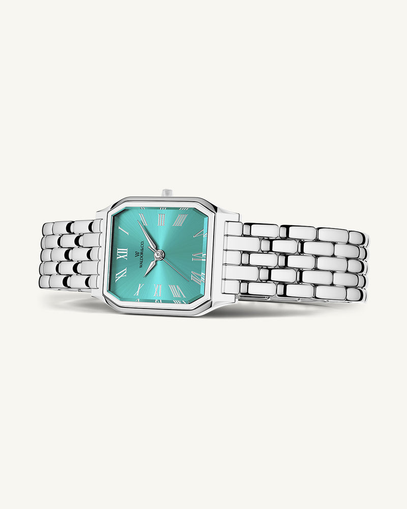 A square womens watch in Rhodium-plated 316L stainless steel from Waldor & Co. with turquoise Diamond Cut Sapphire Crystal glass dial. Seiko movement. The model is Eternal 22 Bellagio.