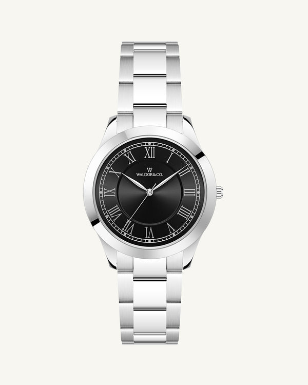 A round womens watch in silver from Waldor & Co. with black sunray dial and a second hand. Seiko movement. The model is Imperial 32 Nocelle 32mm.