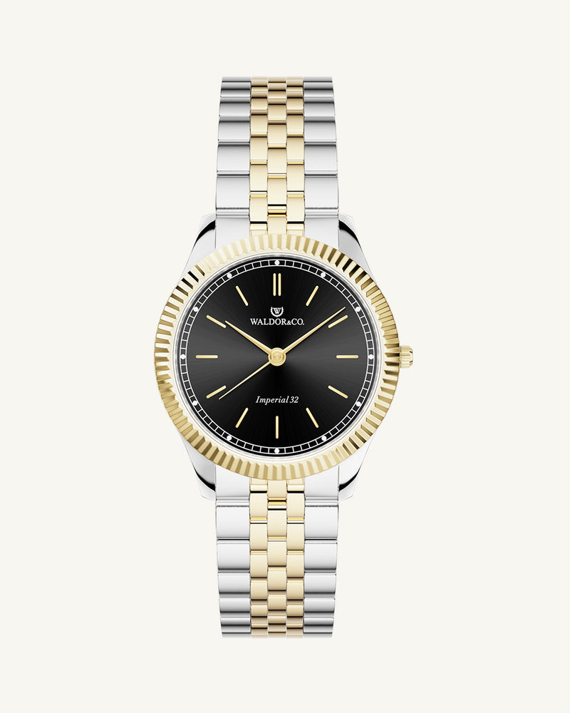 A round womens watch in silver and 22k gold from Waldor & Co. with black sunray dial and a second hand. Seiko movement. The model is Imperial 32 Positano 32mm.