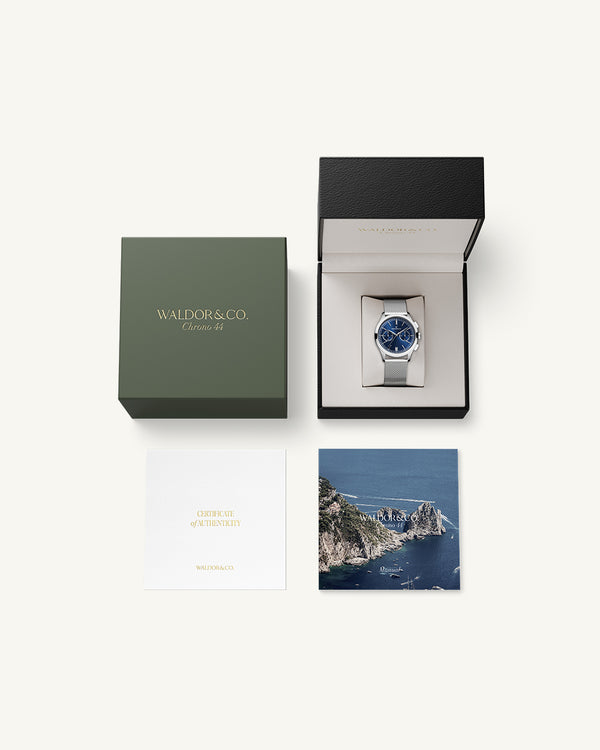 En rund herrklocka i rodiumpläterat silver från WALDOR & CO. med blå sunray urtavla och en sekundvisare. Seiko urverk. Modellen är Chrono 44 Sardinia 44mm. 