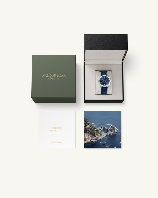 A round mens watch in rhodium-plated silver from Waldor & Co. with blue sunray dial and genuine blue leather strap. A second hand. Seiko movement. The model is Chrono 44 Sardinia 44mm.