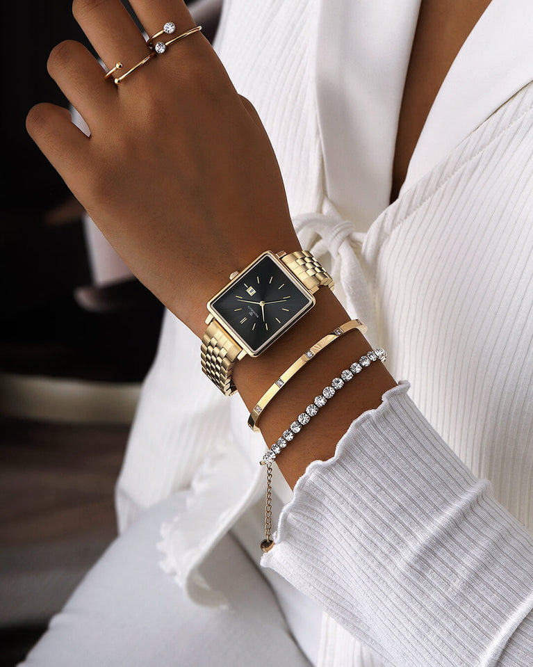 A square womens watch in silver and 14k gold from Waldor & Co. with black sunray dial and a second hand. Seiko movement. The model is Delight 32 Chelsea 28x32mm.