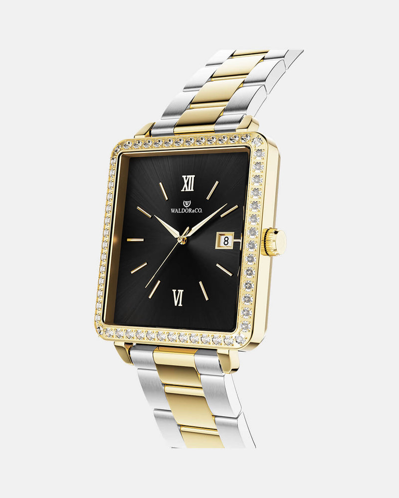 A square womens watch in 22k gold-plated 316L stainless steel with stones from WALDOR & CO. with black sunray dial and a second hand. Seiko VJ22 movement. The model is Delight 32 Mayfair Ltd. Edition 28x32mm. 