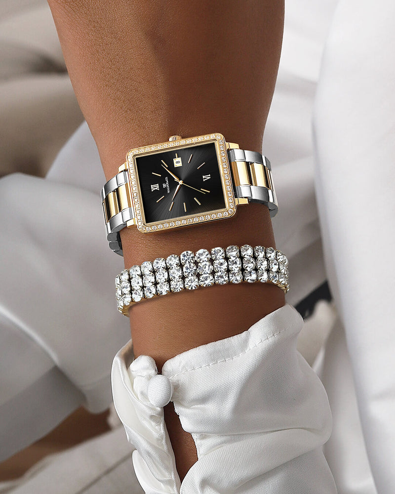 A square womens watch in 22k gold-plated 316L stainless steel with stones from WALDOR & CO. with black sunray dial and a second hand. Seiko VJ22 movement. The model is Delight 32 Mayfair Ltd. Edition 28x32mm. 